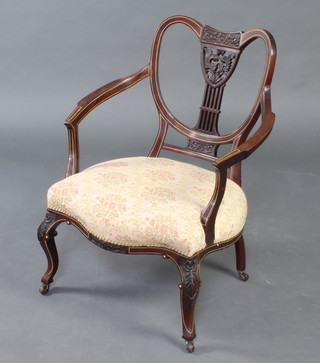 An Edwardian mahogany tub back open arm chair of serpentine outline, inlaid ivory stringings, with upholstered seat  and raised on cabriole supports 