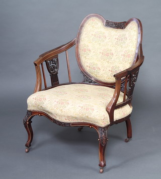 An Edwardian tub back inlaid mahogany open armchair, the seat of serpentine outline, raised on carved cabriole supports 