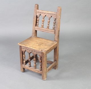 An 18th Century Continental walnut hall chair with bobbin turned decoration and solid seat, raised on square supports 