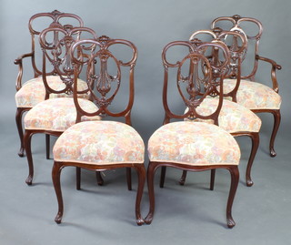 A set of 6 Edwardian mahogany dining chairs with pierced shaped backs and overstuffed seats of serpentine outline, raised on cabriole supports