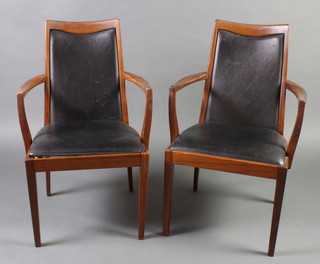 A pair of stylish G-Plan mid 20th Century teak and rexine open arm chairs, raised on square tapered supports 