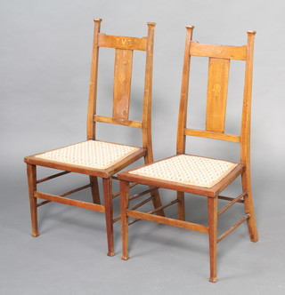 A pair of Edwardian Liberty style Art Nouveau inlaid mahogany slat back bedroom chairs with upholstered seats, raised on square supports 