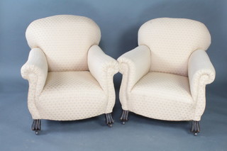 A pair of 1920's Continental style armchairs upholstered in yellow material raised on shaped supports 