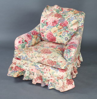 An Edwardian Howard style armchair upholstered in white material and with a floral loose cover