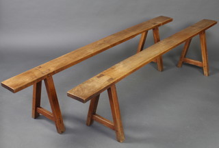 A pair of 19th Century Continental rectangular fruitwood benches raised on trestle supports 45cm h x 192cm l x 15cm w  