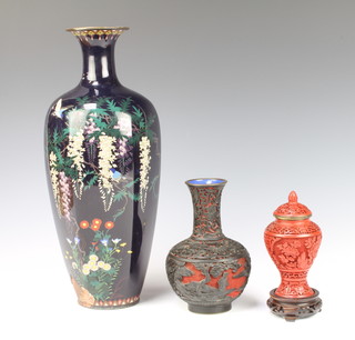 A red Cinnabar lacquer vase and cover 11cm and a ditto club shaped vase 5cm, a black ground cloisonne enamelled vase decorated birds in branches 26cm x 8cm (heavily damaged and dented and hole to the base) 
