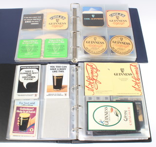 Two albums of Guinness ephemera including beer mats, labels and press clippings