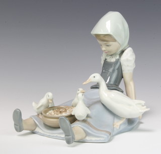 A Lladro figure of a girl seated with duck and ducklings with a bowl of food between her legs no. 5074 16cm, boxed
