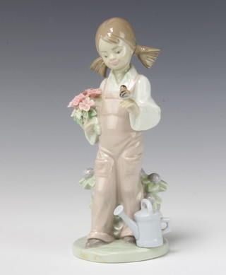 A Lladro figure of a girl holding flowers with a bird on her hand no.5217 18cm, boxed