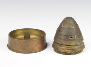 A brass shell nose cone together with a circular Trench Art ashtray formed from the base of a shell 