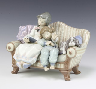 A Lladro group of 2 children and a dog sitting on a settee no. 5735 16cm, boxed  