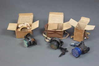 A WWII child's black Mickey Mouse respirator complete with paper carrying case together with 2 civilian respirators with card cases (rubber is perished) 
