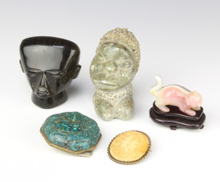 A carved hardstone head and shoulders portrait bust of a man 6cm (chip to base), a Chinese carved hardstone figure of a seated cat 4cm, an African carved hardstone portrait bust of a lady 8cm, a green hardstone belt buckle and a plaster cameo 