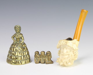 A carved Meerschaum pipe the head in the form of a green man, a brass table bell in the form of a standing lady 9cm, brass model of 3 monkeys 3cm base marked Beerage 