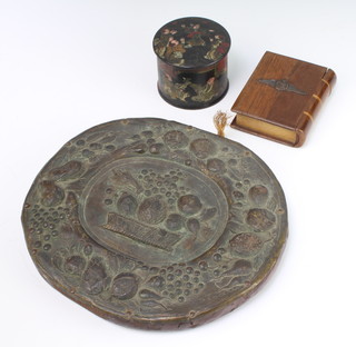 A wooden trinket box in the form of a bible with Royal Flying Corps crest 9cm x 3cm x 7cm, a Continental embossed plaque decorated fruits 19cm x 21cm and a cylindrical lacquered jar and cover decorated figures 6cm x 7cm 
