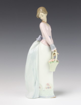 A Lladro figure of a lady holding a basket of flowers no.7622 25cm, boxed
