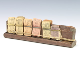 A wooden bus conductor's clip containing a collection of bus tickets including childrens 