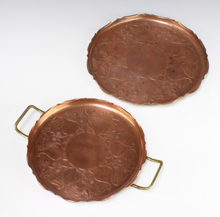 An Art Nouveau circular embossed copper tray with brass twin handles 26cm together with 1 other 30cm (handles missing) 