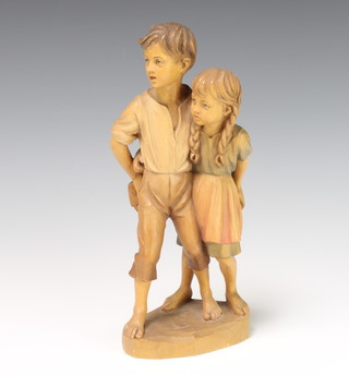 An Austrian carved wooden figure group of a boy and girl on an oval base 24cm h x 10cm w x 7cm d 