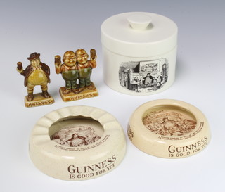 An Ashtead Potters Guinness is Good For You ashtray 11cm, a Woollop Shaw and Robinson ditto 13cm, two Wade Guinness figures and a Carlton Ware cheese dish and cover 9cm 