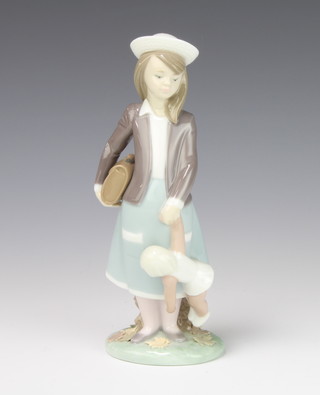 A Lladro figure of a girl holding a satchel and a doll no.5218 20cm 