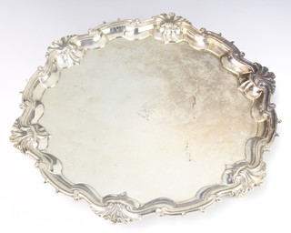 A George II silver salver with shell and scroll rim, raised on scroll feet with chased armorial London 1754, maker WT, 1107 grams 35cm 