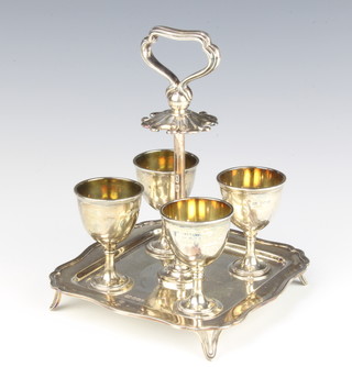 A silver 4 piece egg cruet stand with cups, having a scroll handle, Sheffield 1913, 574 grams