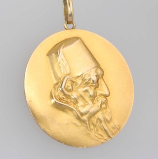 A 10ct yellow gold circular pendant with repousse decoration with the head of a gentleman 4.1 grams gross 