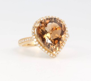 A 14ct yellow gold pear cut champagne topaz and diamond ring, the centre stone approx. 7.43ct surrounded by brilliant cut diamonds approx. 0.34ct, size L 1/2 