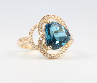 A 14ct yellow gold heart cut blue topaz and diamond ring, the centre stone 3.54ct, surrounded by brilliant cut diamonds 0.35ct, size M 