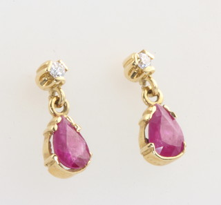 A pair of 18ct yellow gold ruby and diamond ear studs with pear cut rubies 