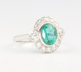 An 18ct white gold emerald and diamond ring the oval set centre stone approx. 1.5ct surrounded by brilliant cut diamonds approx. 0.75ct, size N 1/2