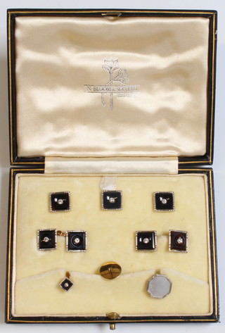An 18ct yellow gold platinum onyx and diamond stud set comprising 3 studs, a pair of cufflinks and a small stud, retailed by Blooms, cased and with 2 other studs