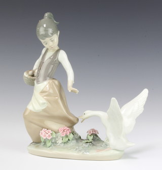 A Lladro figure of a young lady with a goose biting at her skirt no.1288 20cm, boxed