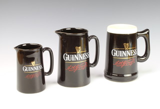 A Guinness black glazed jug 14cm, ditto 19cm and a large mug 16cm 