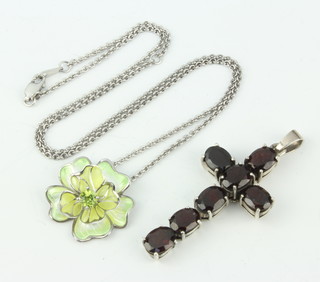 A silver cross pendant set with garnets and a silver chain and floral pendant set a peridot