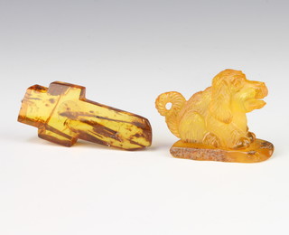 A carved amber figure of a seated dog 5cm, a ditto cross pendant 6.5cm 
