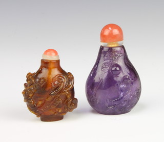 A Chinese carved amethyst scent bottle decorated with dragons having an agate stopper 6cm and an amber ditto decorated with lions 5cm 