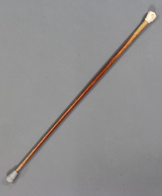A walking cane with a carved ivory clenched fist knot 