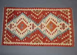 An orange, yellow and turquoise ground Kilim rug with 2 diamonds to the centre 127cm x 72cm 