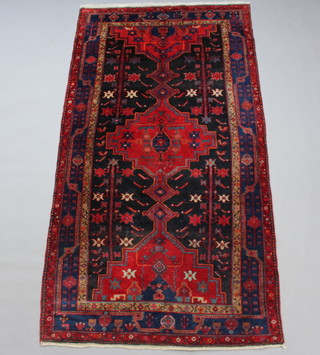A blue and red ground Persian Nahavand carpet with central medallion 288cm x 156cm 