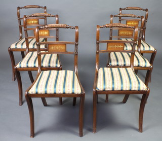 A set of 6 Regency style rope back dining chairs with shaped bar backs and upholstered drop in seats, raised on sabre supports 