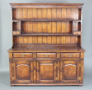 Titmarsh and Goodwin, a 17th/18th Century style oak dresser, the raised back with moulded cornice, fitted 2 shelves flanked by a niche with drawer, the base fitted 3 long drawers above a triple cupboard enclosed by panelled doors 188cm h x 168cm w x 53cm w 