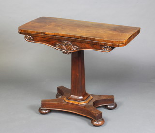 A William IV rosewood D shaped card table raised on a chamfered column and triform base ending in bun feet 74cm x 90cm x 44cm 