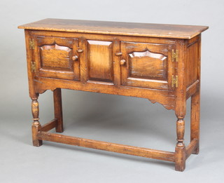 Titmarsh and Goodwin, a 17th Century style oak hutch cabinet fitted a cupboard enclosed by arched panelled doors, raised on turned and block supports 76cm x 107cm x 33cm 