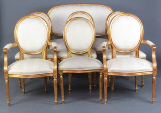 A French style gilt painted salon suite comprising a 2 seat settee, 2 matching armchairs and 4 standard chairs upholstered in light yellow material 