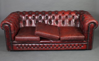 A 3 seat Chesterfield settee upholstered in red buttoned leather 67cm h x 86cm w x 88cm d 

