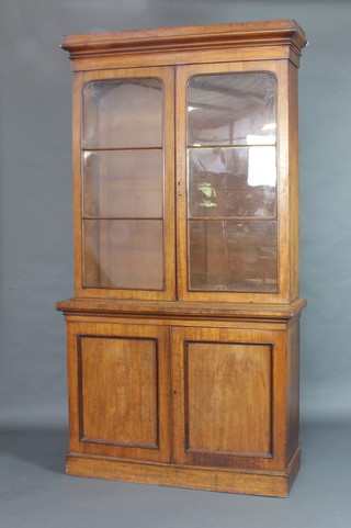 A Victorian mahogany bookcase on cabinet the upper section with moulded cornice, fitted adjustable shelves enclosed by glazed panelled doors, the base fitted a cupboard enclosed by panelled doors 225cm h x 120cm w x 43cm d 