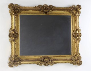 A rectangular plate mirror contained in a rococo style carved and pierced hardwood frame 77cm h x 93cm 