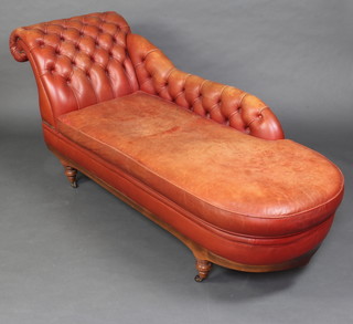 A Victorian style chaise longue upholstered in terracotta buttoned leather, raised on turned supports 83cm h x 194cm l x 67cm d 